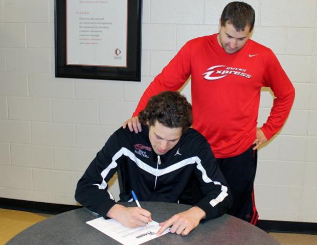 Sophomore Jay Marquette signs his letter of intent to play at Lee University next year, while Express head men's basketball coach Dave Clarke looks on. Photo by Nicholas Huenefeld/Owens Sports Information