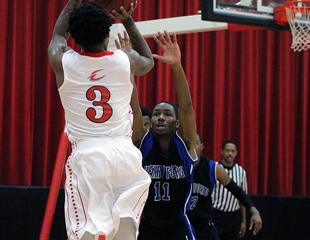 Markese Allen, pictured here draining the 3-pointer that put the Express at the century mark in scoring, helped the Express men's basketball team upend Henry Ford 103-62 in the SHAC tonight. Photo by Nicholas Huenefeld/Owens Sports Information