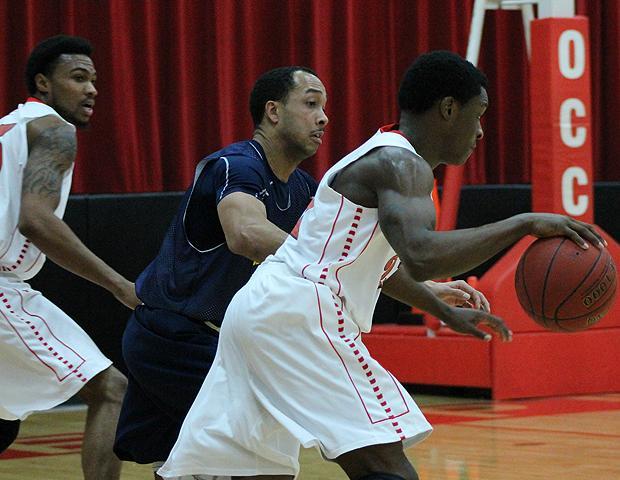 Shavon Gayle (right) looks to drive the ball against an Akron club defender while DeVondre Peoples (far left) looks on. Gayle had a season-high 18 points in the 104-36 victory. Photo by Cassie Hoffmann/Owens Sports Information