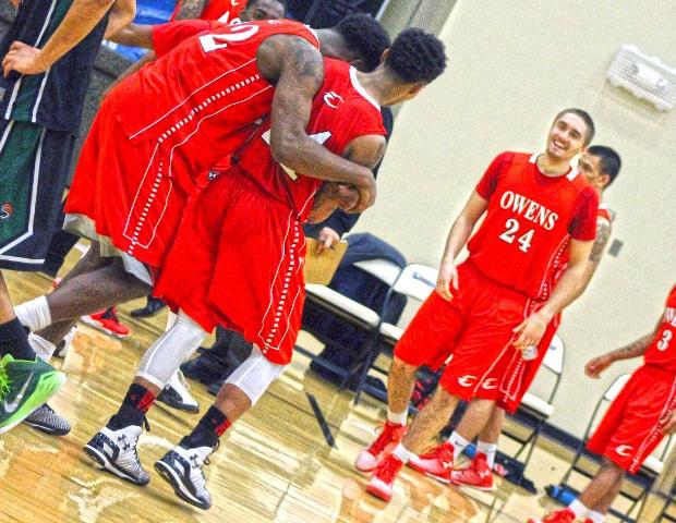 Edmond Early Jr., right, is hugged by Darren Groves after Early Jr.'s late three's sealed a win tonight. Photo by Sierra Harley/Owens Sports Information