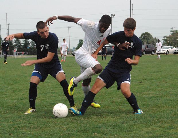 Vijay Gentles looks to make a move between two Schoolcraft defenders. The teams battled to a 1-1 tie through 2 OTs. Photo by Nicholas Huenefeld/Owens Sports Information