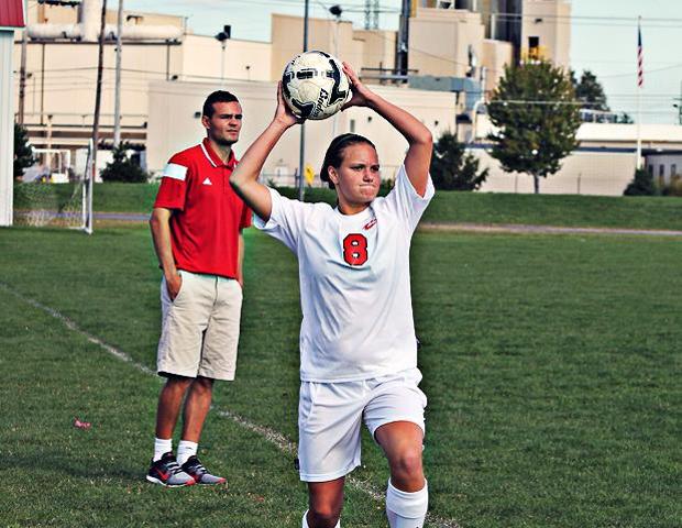 Kayla Lehmann throws a ball in as head coach Kenny Hewitt looks on. Photo by Kyle Whitaker/Owens Sports Information