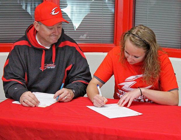 Express softball head coach Duane Lanham watches as Brittany George signs her letter of intent to play for the Express next year. Photo by Nicholas Huenefeld/Owens Sports Information