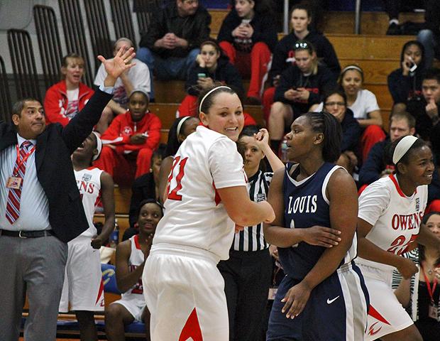 Meshia Smith, far right, Mackenzie Heacock, center, and head coach Mike Llanas (far left) celebrate after Smith's 3-pointer from the right corner in the second half of today's win over St. Louis CC. Smith totaled 14 points, 10 rebounds and four blocks. Photo by Nicholas Huenefeld/Owens Sports Information