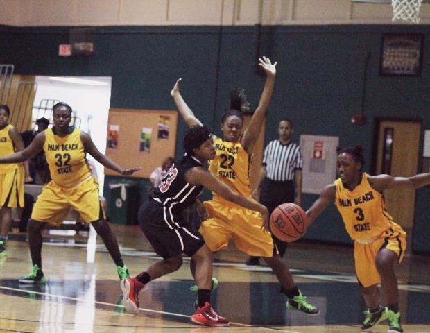 Sierra Harley, in traffic, dishes out to an open 3-point shooter just in time during the second half of today's 89-81 win over Palm Beach. The freshman guard had 21 points and six assists. Photo by Nicholas Huenefeld/Owens Sports Information