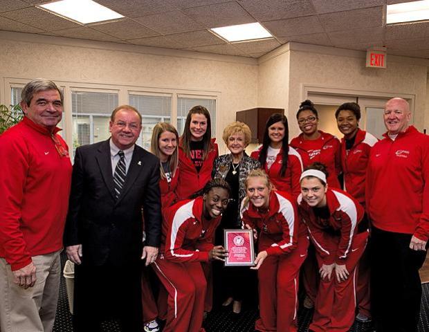 Members of the Express volleyball team and their coaches pose for a picture with Owens Community College President, Dr. Mike Bower (left, in suit) and Dee Talmage, Owens Board of Trustees Chair (center). Photo by Seth Foley/Owens Sports Information